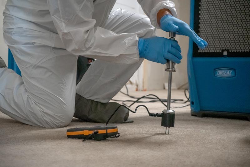 technician testing floor for moisture